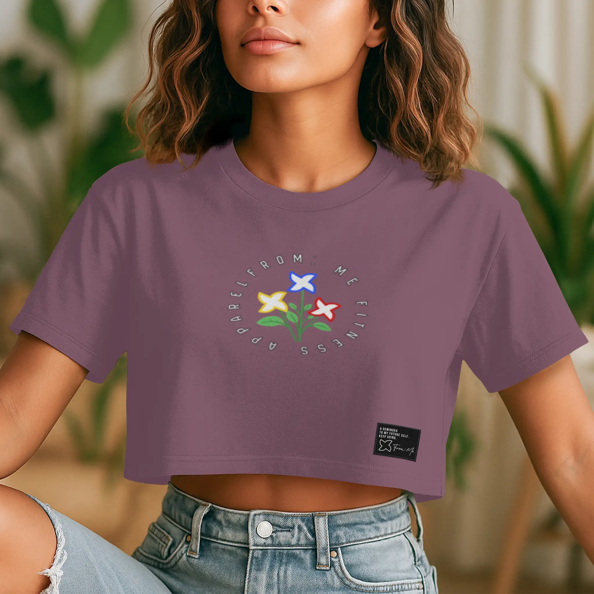 Person wearing a purple t-shirt with a floral design and text.