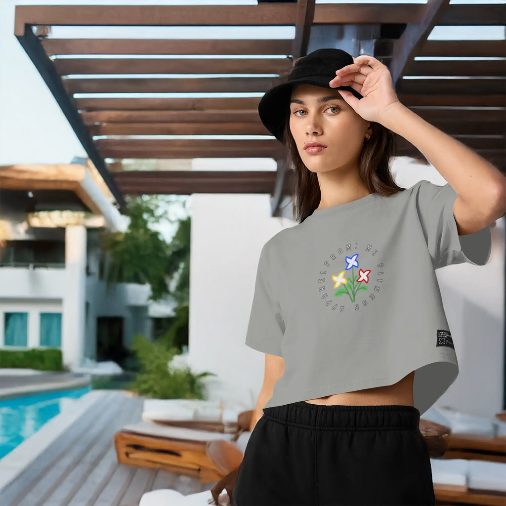 Woman wearing a gray t-shirt with text and black shorts, standing outdoors near a pool.