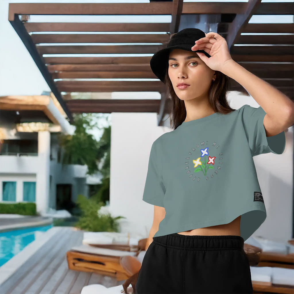 Woman wearing a green t-shirt and black shorts standing by a poolside.