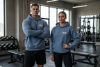 Two people wearing blue hoodies with 'Lifting Life' logo in a gym setting.