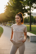 Woman wearing a 'From Me' t-shirt in a park setting